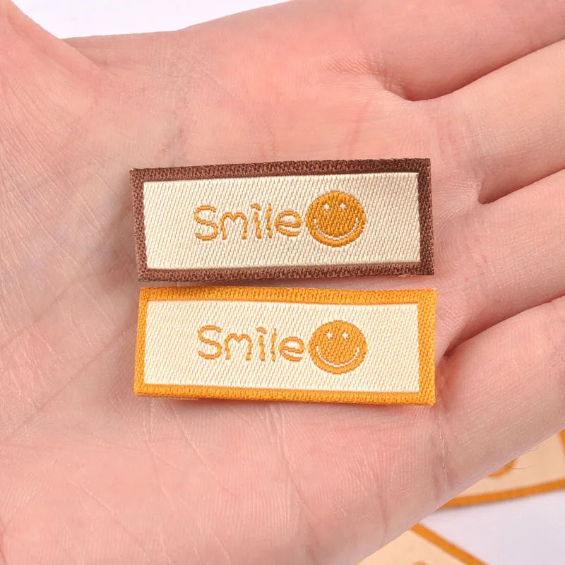 50Pcs/Lot Cartoon Embroidery Washable Care Labels For Clothing Sewing Accessories Bags Smlie Face Tags Garment DIY Crafts c3207 Qme