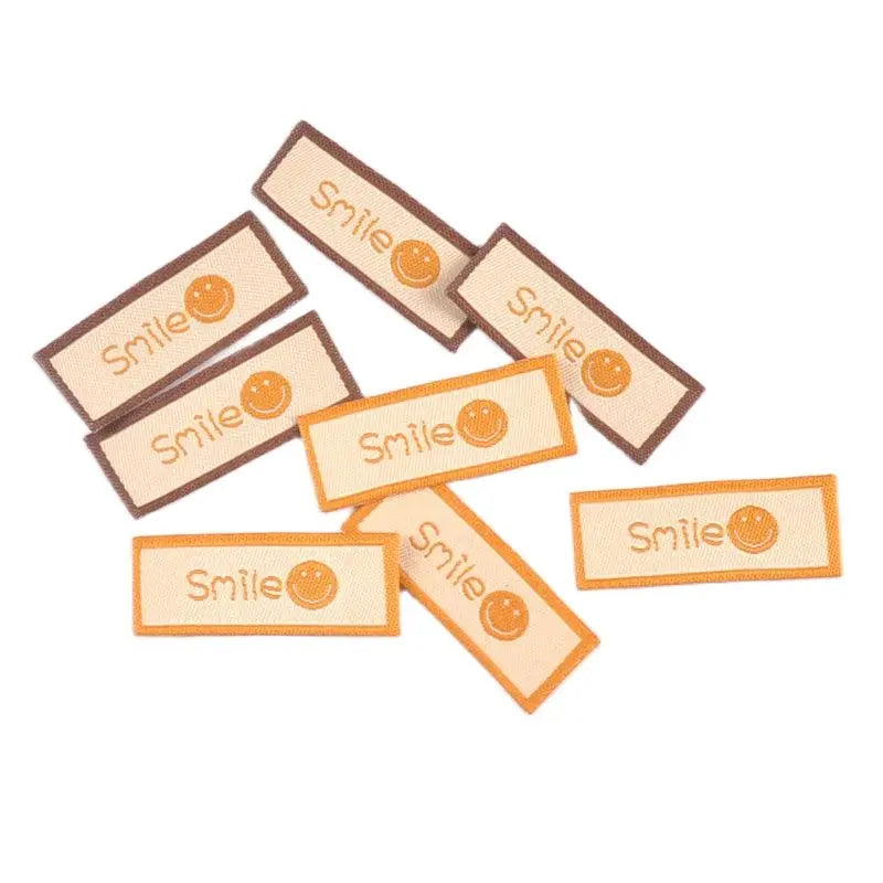 50Pcs/Lot Cartoon Embroidery Washable Care Labels For Clothing Sewing Accessories Bags Smlie Face Tags Garment DIY Crafts c3207 Qme