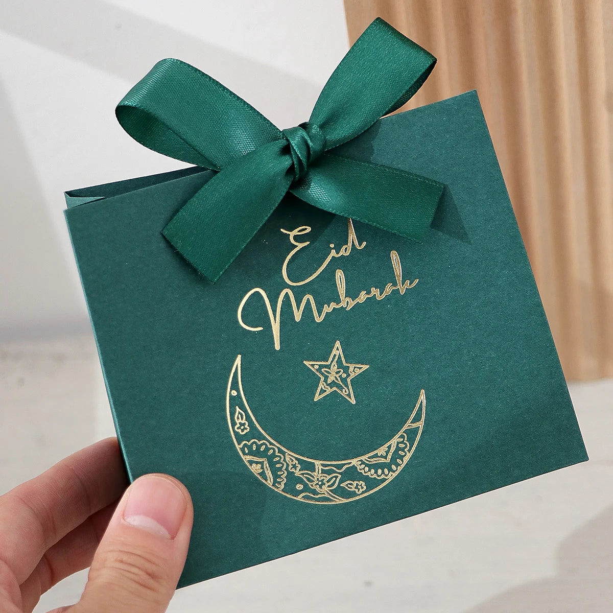 5 Exquisite and Compact Eid Gift Boxes, Available in Elegant Black, Luxurious Green, and Pure White, Decorated with Delicate Gold and Silver Star and Moon Patterns, and Adorned with Luxurious Gold and Silver Ribbons. These Gi Qme