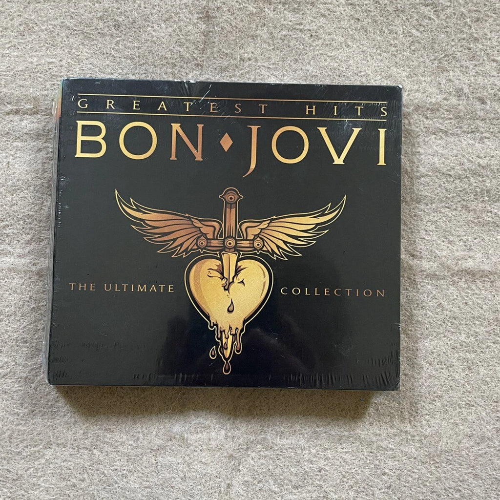 Rock Music CD Album with Bold Black & Gold Art Cover, Eye-Catching Sword-Heart-Wings Logo + High-Energy Rock TracksC Qme Greatest Hits