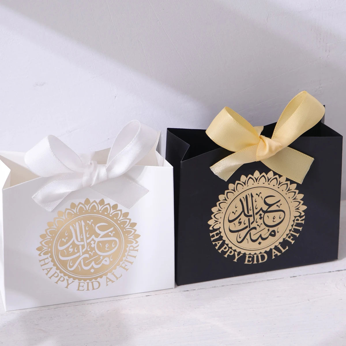 5 Exquisite and Compact Eid Gift Boxes, Each Featuring Elegant Black, Luxurious Green, and Pure White as Their Main Colors, Adorned with Delicate Arabic Script and Golden Circles, and Tied with Luxurious Gold and Silver Ribbo Qme