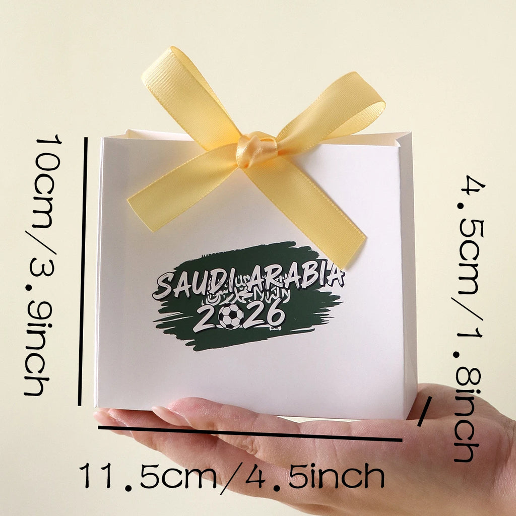Saudi Arabia 2026 Football-Themed Gift Box, Simple White Box with Green Football Print, Adorned with a Delicate Yellow Satin Ribbon Bow, Featuring a Clean and Elegant Design The Box Has Clear Printing and a Fine Texture, Maki Qme