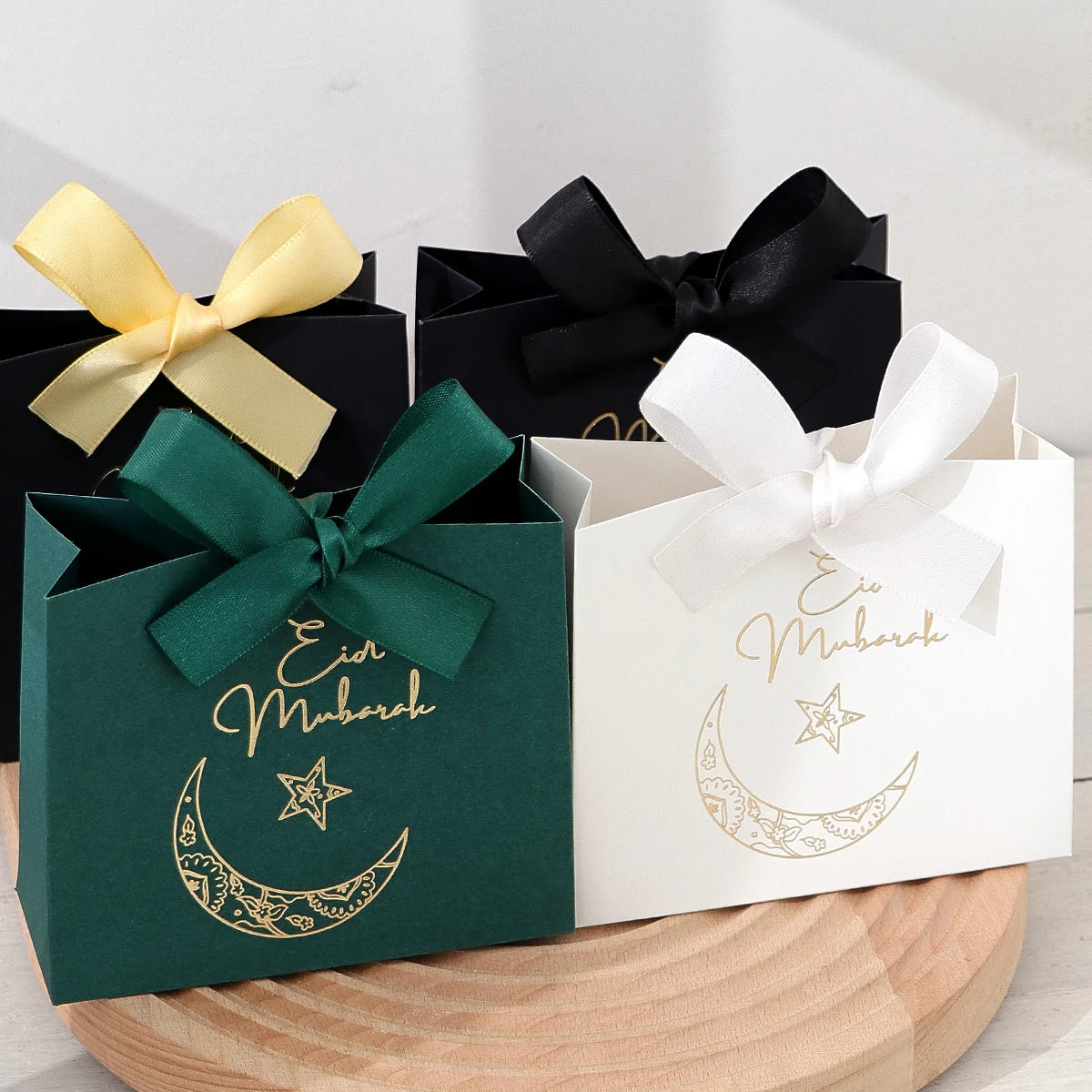 5 Exquisite and Compact Eid Gift Boxes, Available in Elegant Black, Luxurious Green, and Pure White, Decorated with Delicate Gold and Silver Star and Moon Patterns, and Adorned with Luxurious Gold and Silver Ribbons. These Gi Qme