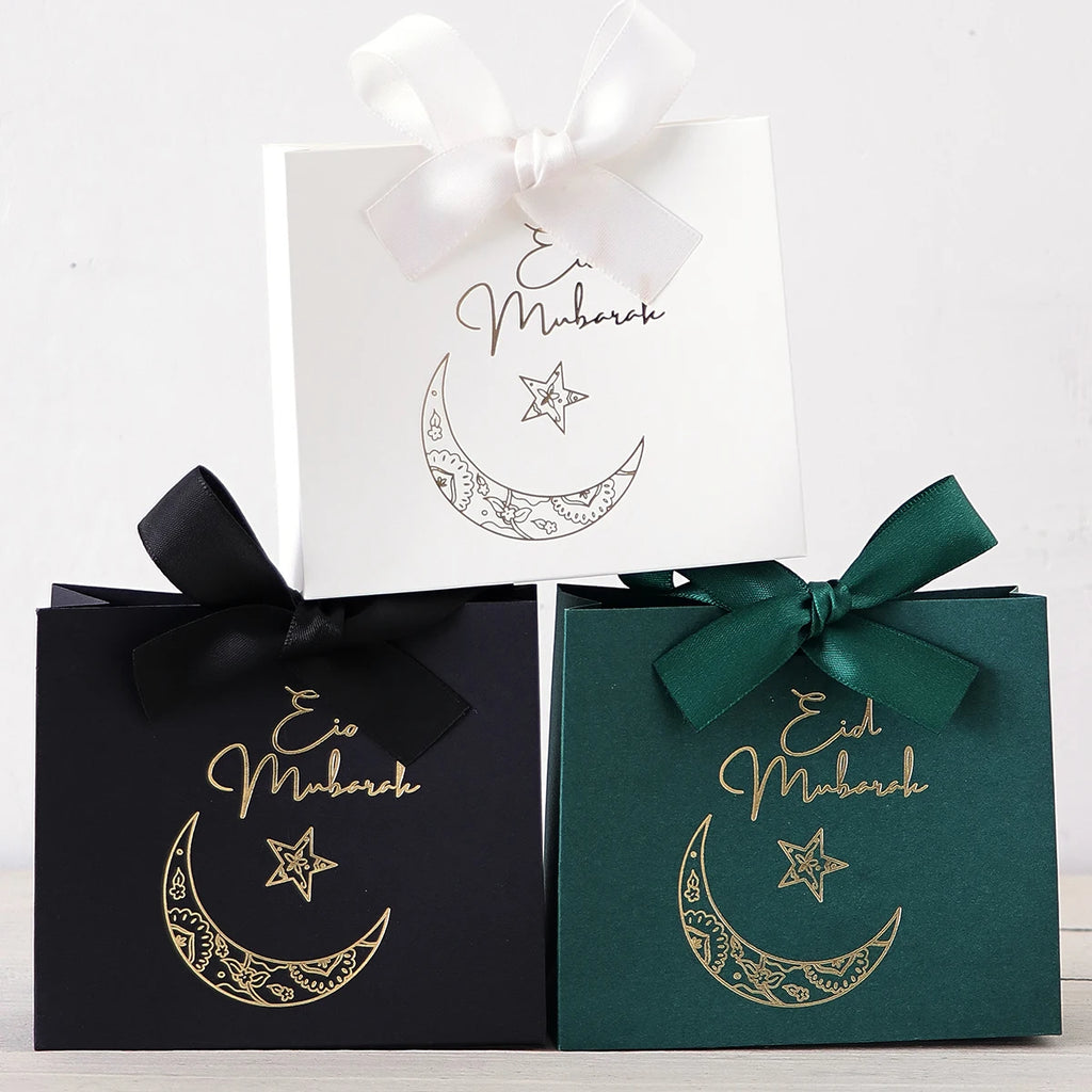 5 Exquisite and Compact Eid Gift Boxes, Available in Elegant Black, Luxurious Green, and Pure White, Decorated with Delicate Gold and Silver Star and Moon Patterns, and Adorned with Luxurious Gold and Silver Ribbons. These Gi Qme
