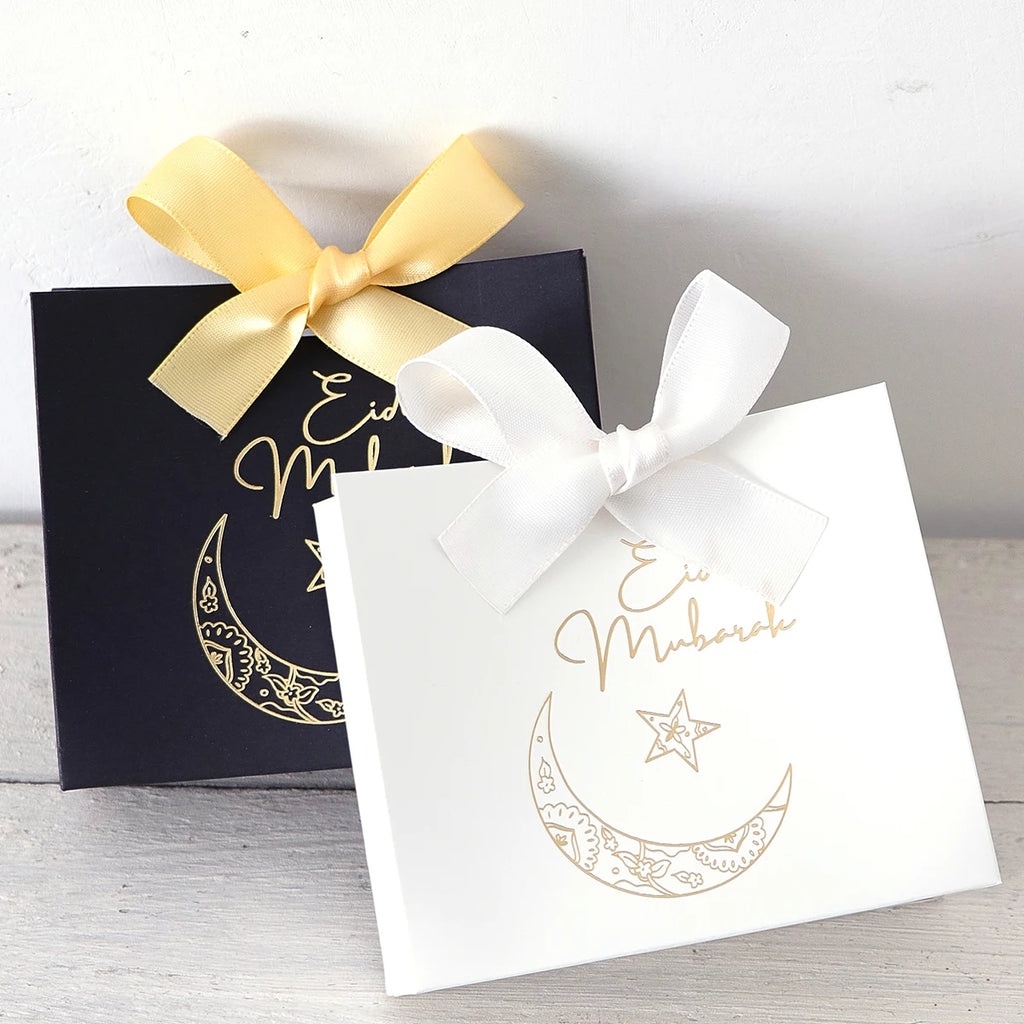 5 Exquisite and Compact Eid Gift Boxes, Available in Elegant Black, Luxurious Green, and Pure White, Decorated with Delicate Gold and Silver Star and Moon Patterns, and Adorned with Luxurious Gold and Silver Ribbons. These Gi Qme